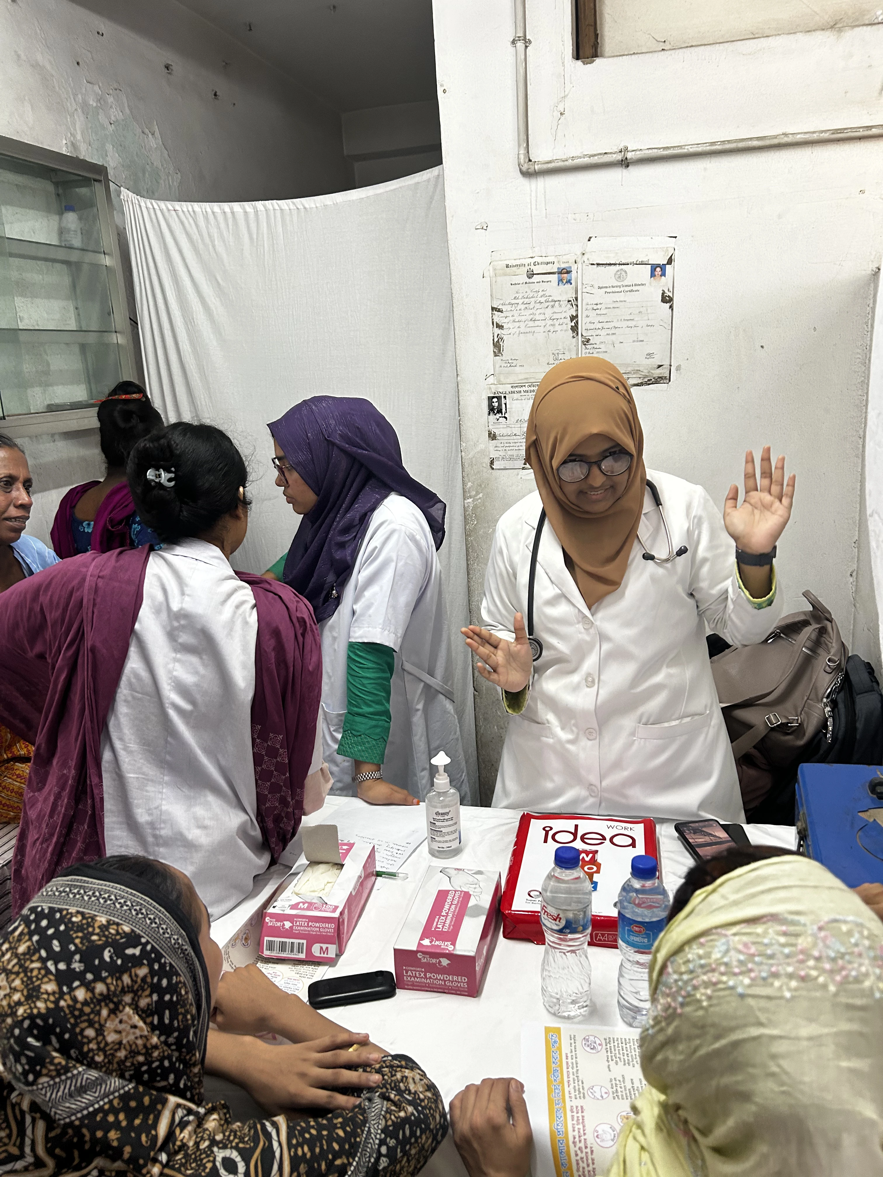 Medical staff performing a clinical breast exam during a factory screening camp